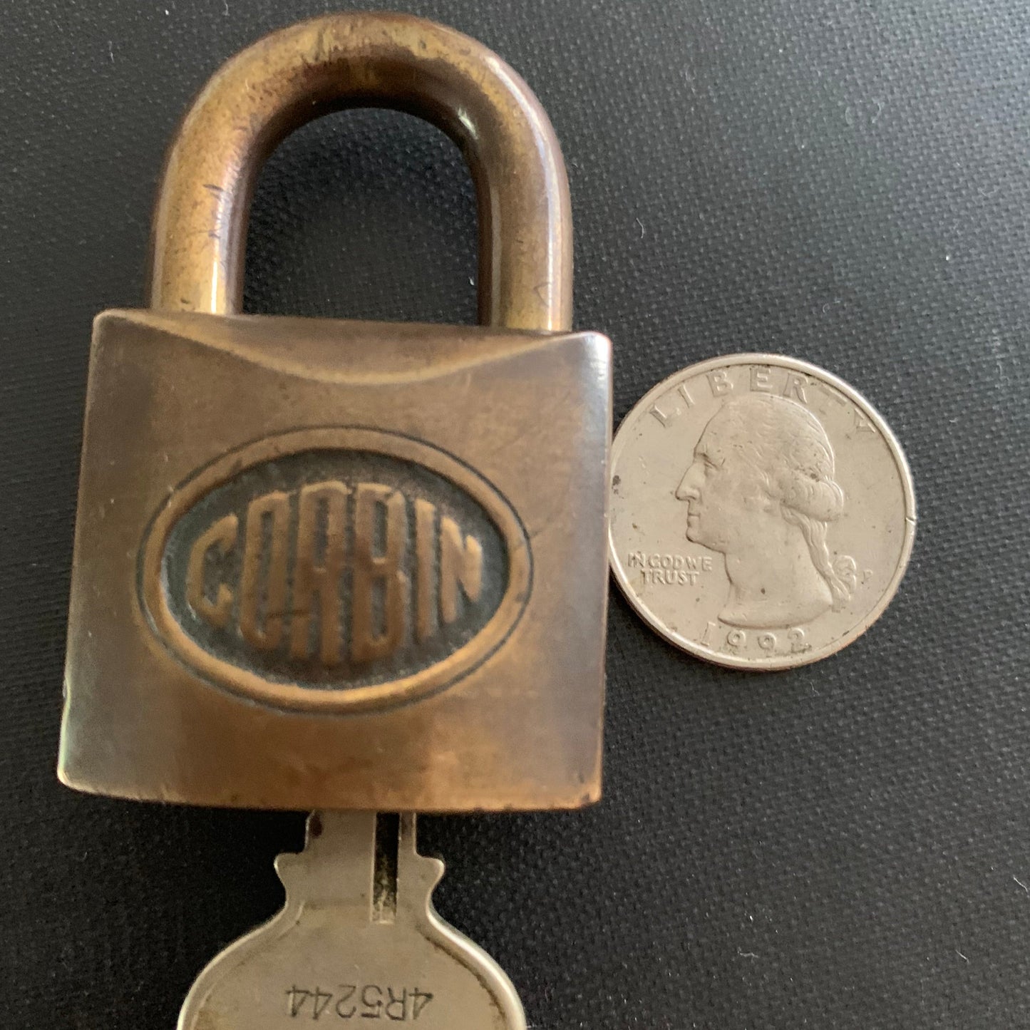 corbin lock sized next to a quarter
